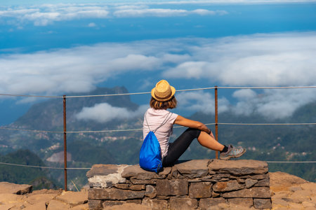 A young woman sitting at the Miradouro do Juncal on Pico do Arieiro, Madeira. Portugalの写真素材