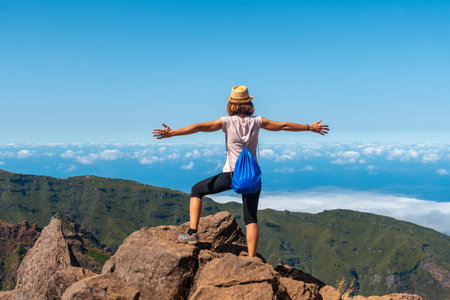 A young woman enjoying the freedom at Miradouro do Juncal on Pico do Arieiro, Madeira. Portugalの写真素材