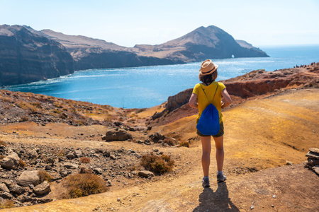 A young woman tourist on the Ponta de Sao Lourenco trail in the Baia D'Abra, Madeira coastの写真素材