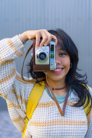 Portrait of a young Asian woman photographing with a vintage photo camera, vacation concept, tourist...