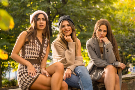 Portrait of carefree women friends in a park in autumn, fashionable autumn lifestyle with positive energyの写真素材