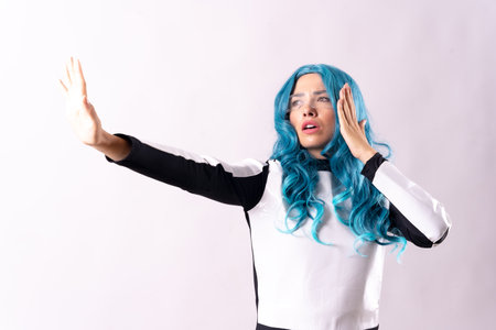Futuristic concept, a young woman with blue hair, luminous glasses and a galactic suit. gesticulatingの写真素材