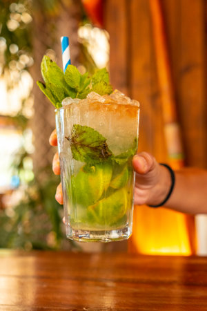 A young girl refreshing herself in the summer with a Mojito cocktail on vacationの写真素材