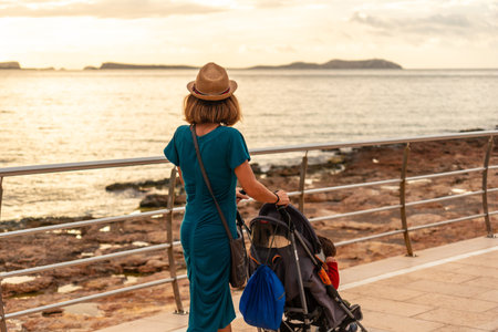 A mother watching the sunset on the Paseo de Poniente in San Antonio Abad, Ibiza Island. Balearicの写真素材