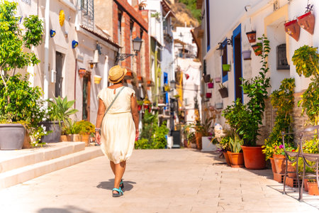 A tourist woman visiting the Santa Cruz neighborhood in Alicante, Mediterranean houses. Valenciaの写真素材