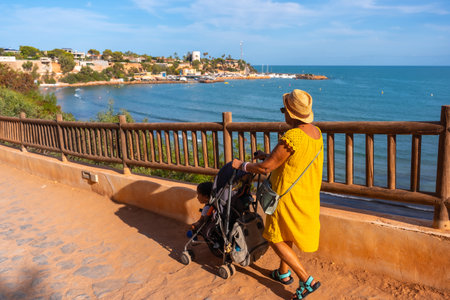 Grandmother walking with her grandson on the Caleta beach in the tourist town of Cabo Roig. Alicanteの写真素材