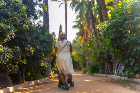 A grandmother walking with her grandson in the El Palmeral park in the city of Alicanteの写真素材