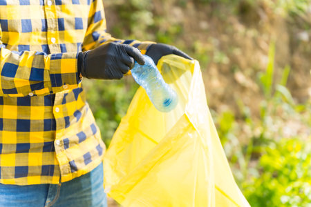 Unrecognizable person collecting plastics in a forest. Ecology concept, recyclingの写真素材