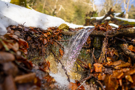 Small waterfall in the river with snow in winter in the Artikutza natural park, Gipuzkoaの写真素材