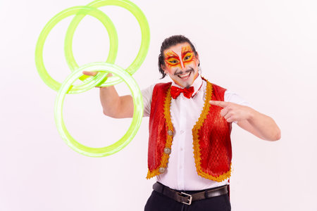 Portrait of a juggler smiling with juggling hoops isolated on white backgroundの写真素材
