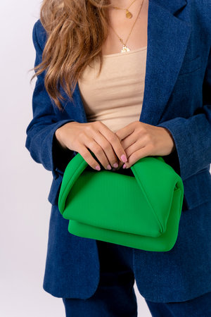 Hand of a businesswoman with a green bag on a white background, fashion studioの写真素材
