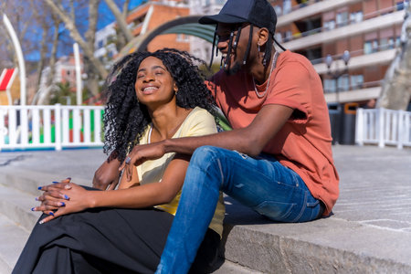 Young african american women in the city, lifestyle concept friends, sitting in a park laughingの写真素材