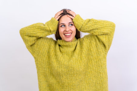 Close up portrait of young, cheerful isolated on white studio background in green woolen pulloverの写真素材