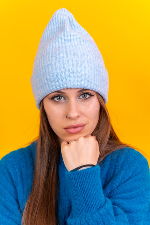 Close up portrait of a young caucasian woman wearing blue wool sweater isolated on background, looking at cameraの写真素材