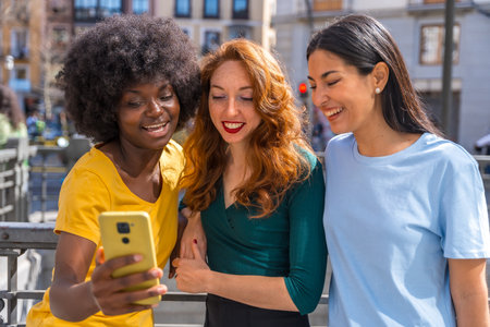 Three multiracial young women taking a selfie in the city, friendship concept, feminismの写真素材