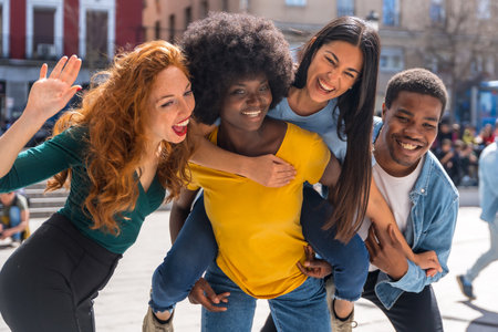 Happy multiethnic friends in the city with rise on the back and smiling taking a selfieの写真素材