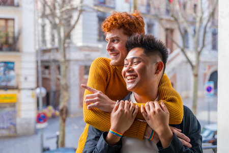 Beautiful gay couple being romantic at home on the sofa, hugging on the balcony at home, lgbt conceptの写真素材