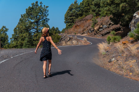 A female tourist walking on the road next to the El Julan viewpoint on the El Hierro, Canary Islandsの写真素材