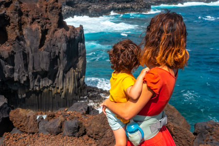 A mother with her son walking on the volcanic trail in the village of Tamaduste on the island of El Hierro, Canary Islands, Spainの写真素材