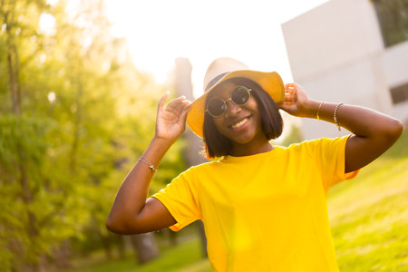 Golden Hour: A Beautiful Black Woman Basks in the Warmth of Summer in the Forestの写真素材