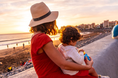 Mother and son at sunset on the beach of Valle Gran Rey in La Gomera, Canary Islands. sitting enjoying the sunの写真素材