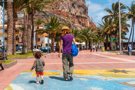 Walking along the promenade in the city of San Sebastian de la Gomera and its Iglesia De La Asuncion, Canary Islandsの写真素材