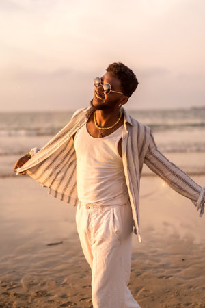 Portrait of attractive black ethnic man enjoying summer vacation by the sea feeling freeの写真素材