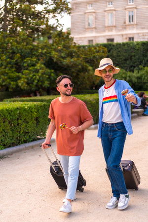 Male tourists gay boyfriends with a suitcase in the park on sunset in the city visiting the city....