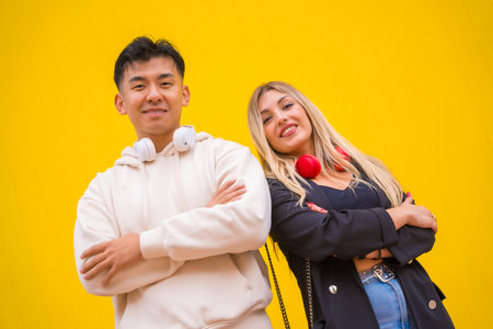 Portrait of a multiethnic couple of Asian man and Caucasian woman on a yellow backgroundの写真素材