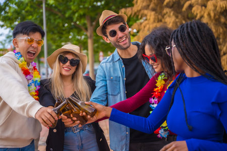 Group of multi ethnic friends partying in a park - Diverse young people toasting with glass bottles of beer at a summer party, youth conceptの写真素材
