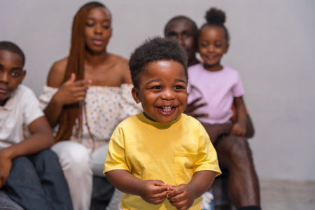 African black ethnic family with children on sofa at home, portrait of child smilingの写真素材