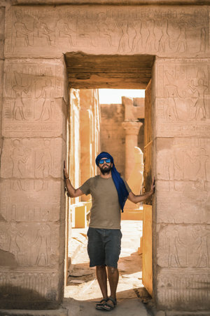 Portrait of a young man with a blue turban at the entrance to the Edfu Temple near the city of...