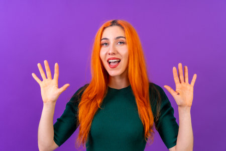 Redhead woman in studio photography making the astonished gesture on a purple backgroundの写真素材