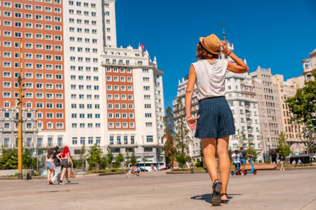 Young woman with tourist hat in the Spain square in the center of the capital of Madrid enjoying the holidays in summerの写真素材