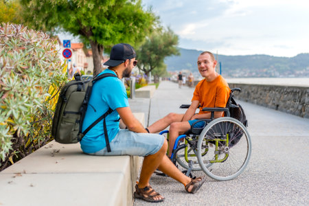 A disabled person in a wheelchair with a friend on summer vacationの写真素材
