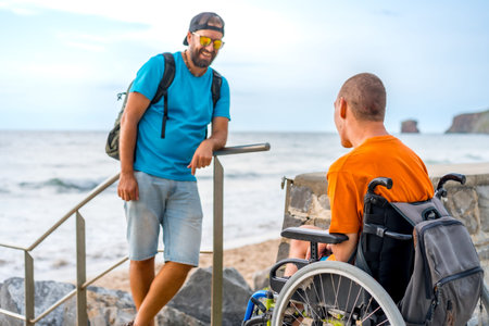 A disabled person in a wheelchair with a friend in the summer vacation by the sea
