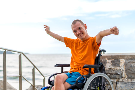 Portrait of a very cheerful disabled person in a wheelchair on vacationの写真素材