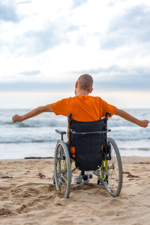 A disabled person on his back in a wheelchair on the beachの写真素材