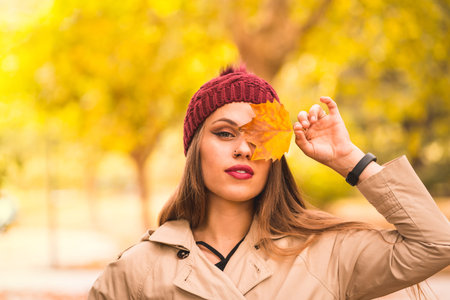Outdoor atmospheric lifestyle portrait of a beautiful young woman in a forest in autumn