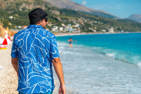 A young tourist from behind walking on the beach of the Albanian riviera called Borsh in Vlore, Albaniaの写真素材