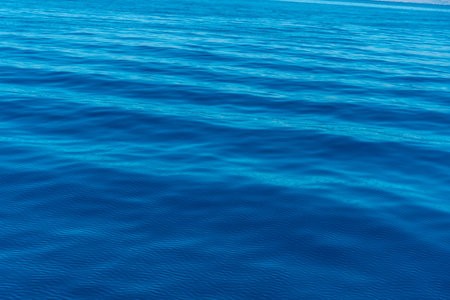 Turquoise sea water texture with sun rays in the Albanian Mediterranean Sea on the Albanian Riviera