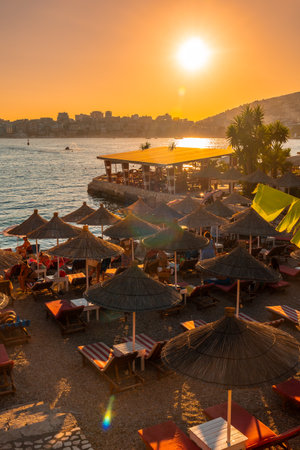 Beautiful resort with umbrellas and palm trees by the sea at sunset in Sarande or Saranda on the Albanian riviera, Albaniaの写真素材