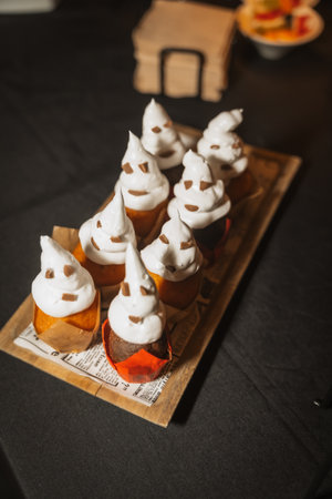 Halloween food and sweets in the shape of pumpkins at a party, chocolate ghost cupcakesの写真素材