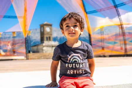 Portrait of a child in the colorful arches in the Ottoman Castle Fortress of Gjirokaster or...