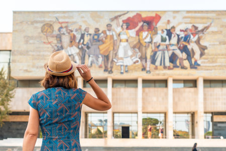 A female tourist with her back turned at the entrance to the National Historical Museum in Skanderbeg Square in Tirana. Albaniaの写真素材
