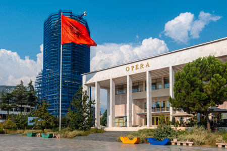 Palace of Culture or Opera on Skanderbeg Square in Tirana and the flag of Albania moving in the windの写真素材