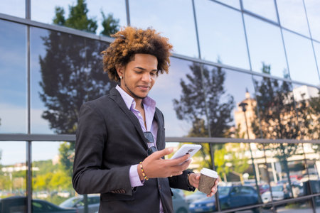 Portrait with copy space of an African American businessman using mobile on a coffee breakの写真素材