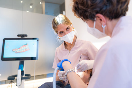 Team of dentists working with a male patient in a modern clinic