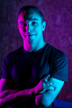 Studio portrait with blue and purple neon lights of a proud handicap sports personの写真素材