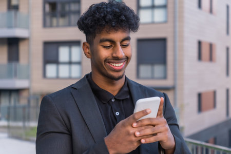 Portrait of a happy arab businessman using phone outside a building